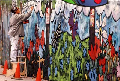 Laurie Zeszut painting a mural on Pacific Avenue, Santa Cruz, CA
